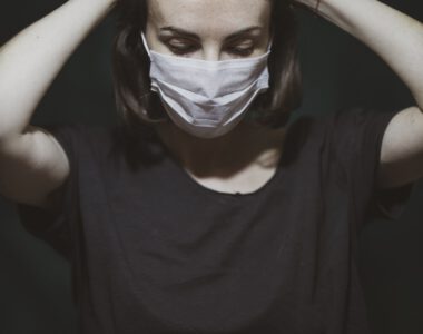 Frau Arzt mit Mundschutz schlägt Hände übern Kopf Stress